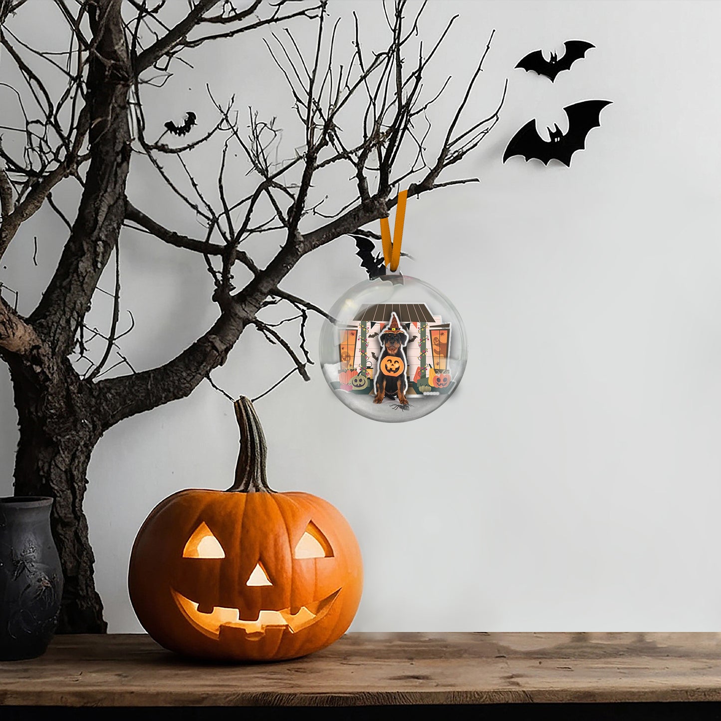 Halloween-themed ornament with a dog in a pumpkin and bats on a tree branch.