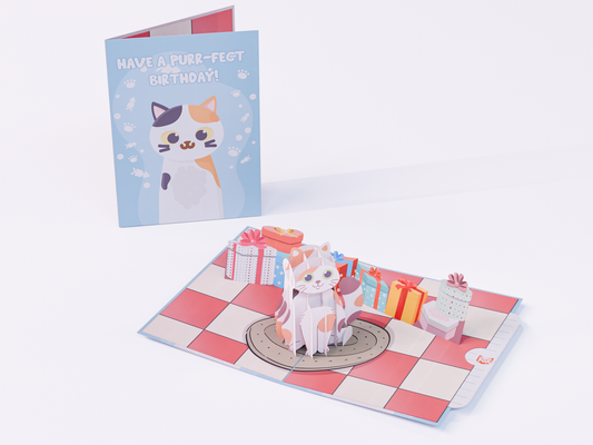 Pop-up birthday card with a 3D calico cat, gift boxes, cupcake, and “Have a Purr-fect Birthday” message in pastel colors